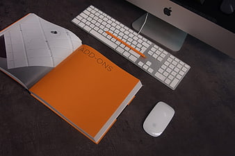 Modern workspace with orange book and Apple computer