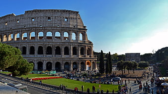 Colosseum in Rome, Italy with tourists and Arch of Constantine
