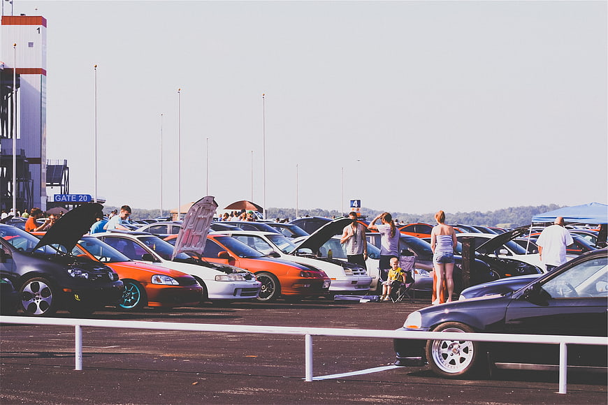 Outdoor car show with modified vehicles and spectators