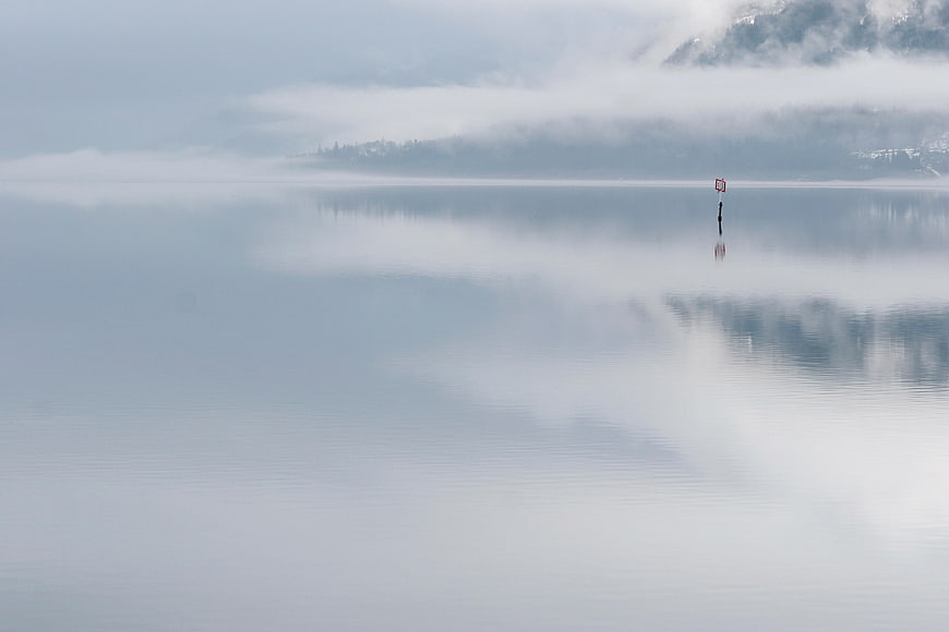 Serene Misty Lake with Foggy Mountain Reflections