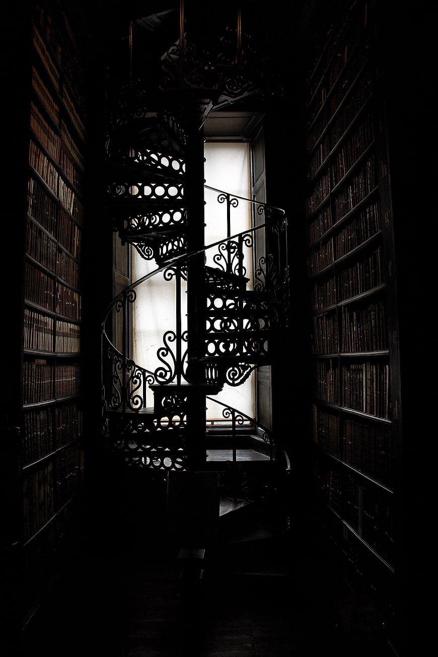 Dark Spiral Staircase in Historic Library with Bookshelves