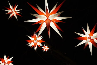 Glowing red and white Christmas star lanterns at night