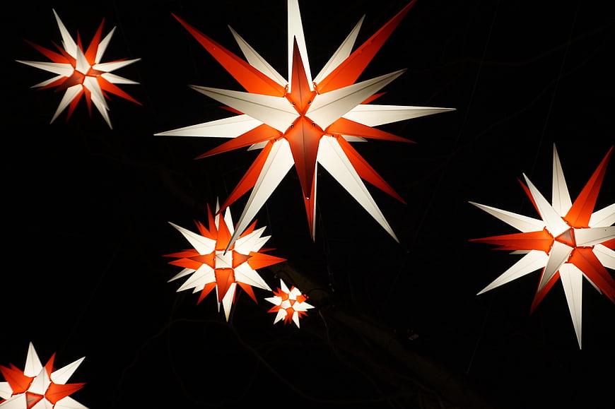 Glowing red and white Christmas star lanterns at night