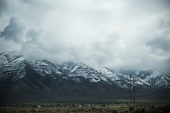 Snow-Capped Mountains Under Dramatic Cloudy Sky