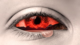 Surreal red eye with mountain landscape and tear drop