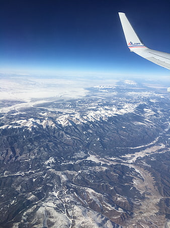 Aerial View of Snow-Covered Mountains from Airplane Window
