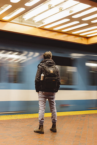 Man with Backpack Waiting for Moving Subway Train