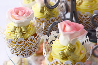 Elegant pink rose cupcakes with gold bows on tiered stand