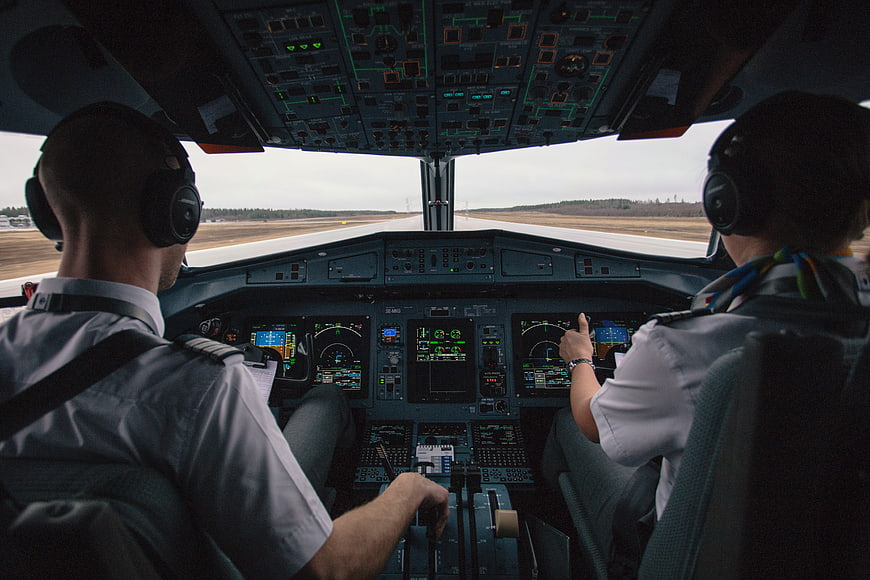 Two pilots in airplane cockpit on runway