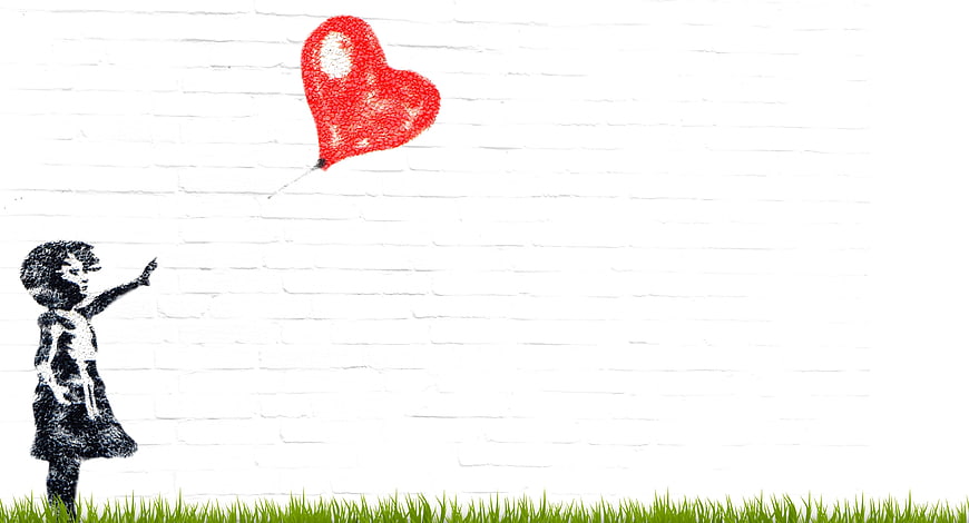 Street art mural of girl reaching for red heart balloon