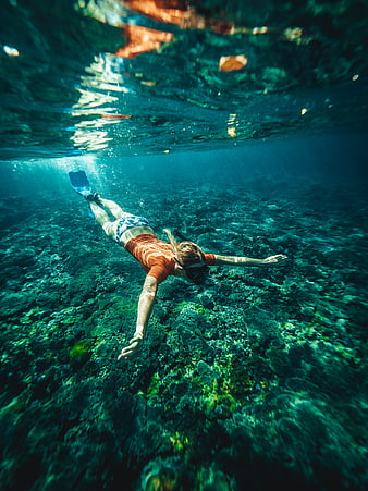 Woman Snorkeling Underwater in Clear Blue Ocean