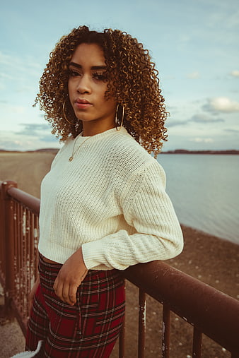 Stylish Woman with Curly Hair by the Sea