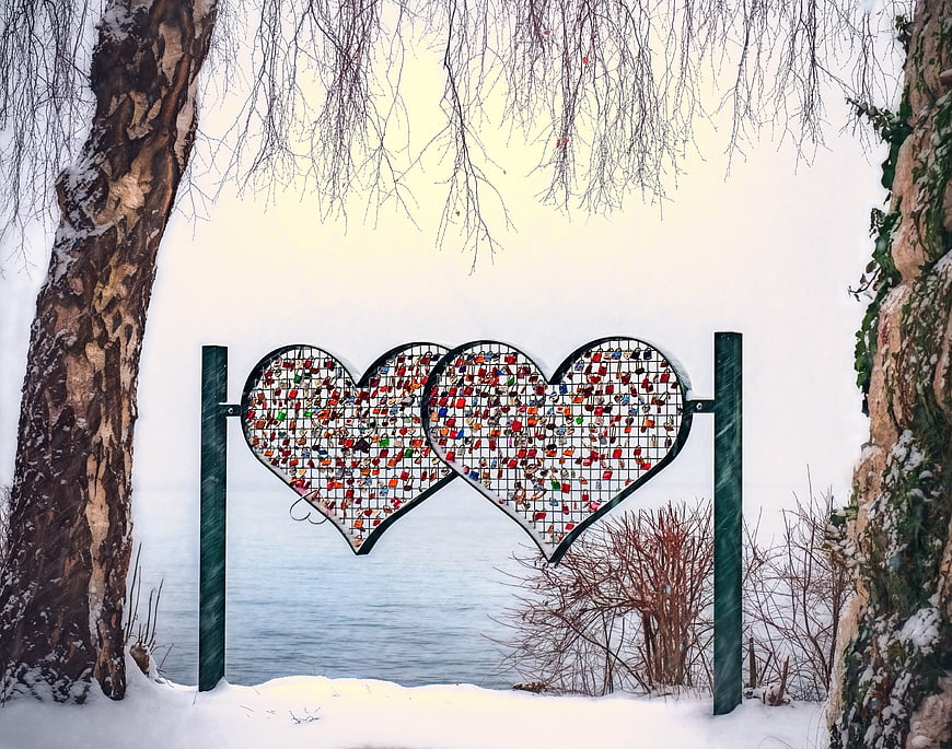 Two heart-shaped love lock fences in a snowy winter landscape