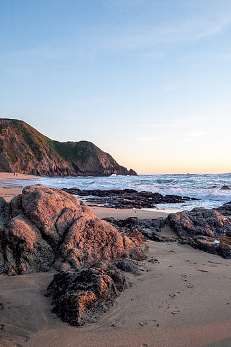 Golden Hour Rocky Beach with Ocean Waves and Cliff