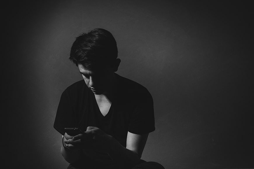 Moody Black and White Portrait of Man Texting on Smartphone