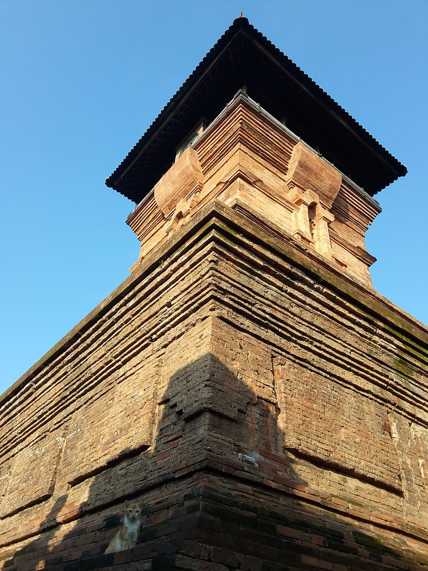 Low angle view of ancient brick minaret with cat