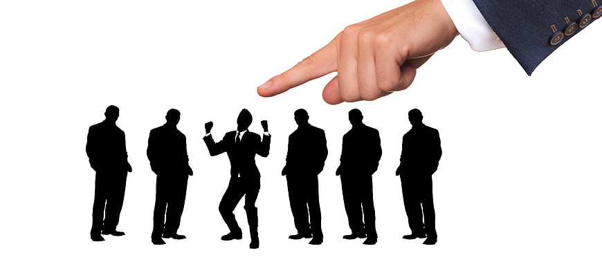 Hand pointing at selected business silhouette from group