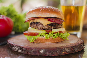 Delicious Bacon Cheeseburger on Wooden Board with Beer