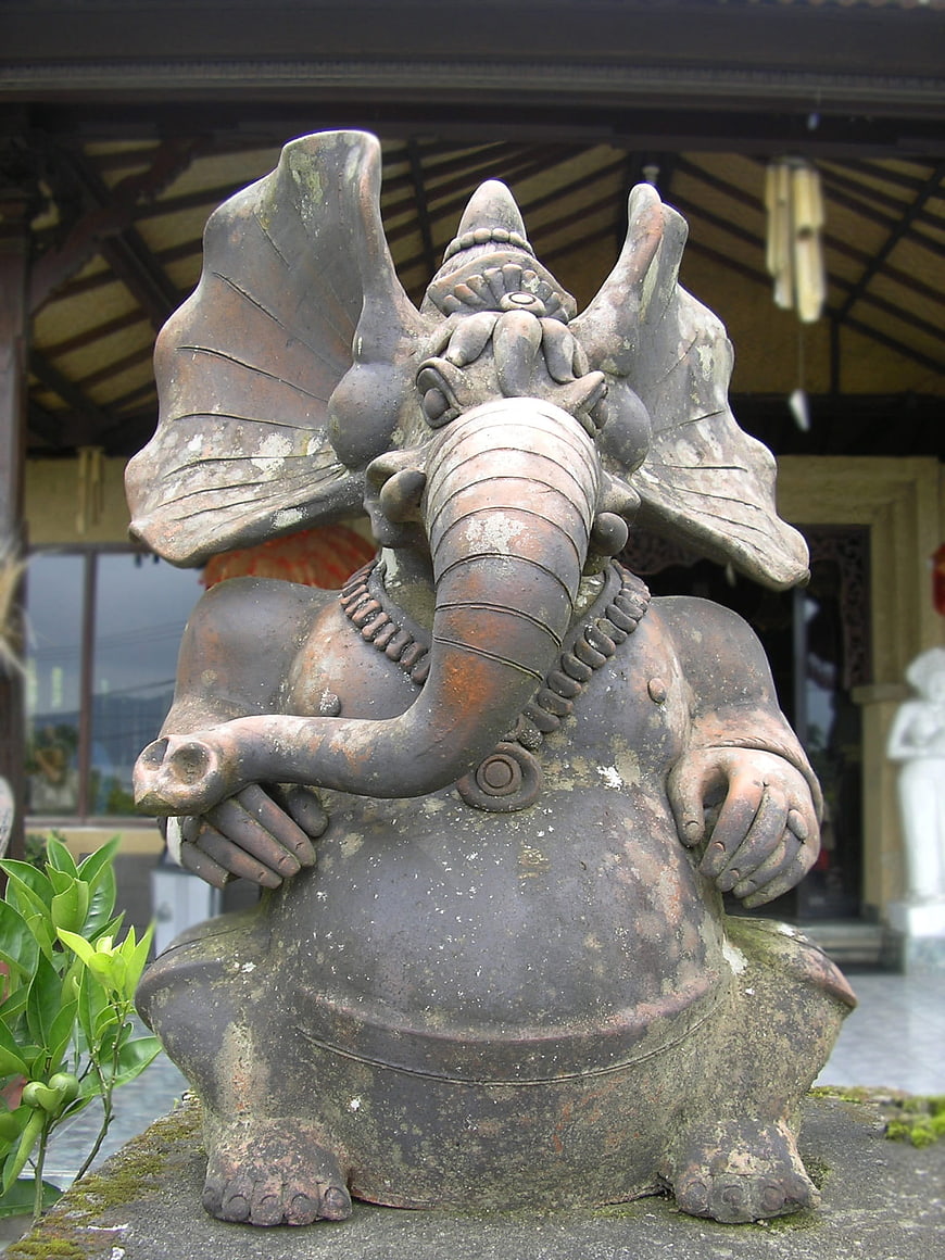 Weathered Stone Ganesha Statue in Garden Setting