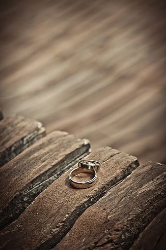 Two Silver Wedding Bands on Rustic Wooden Planks