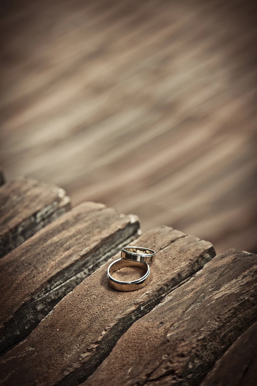 Two Silver Wedding Bands on Rustic Wooden Planks