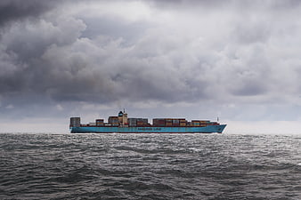 Maersk Line container ship sailing on rough seas under stormy clouds
