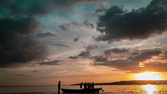 Silhouetted Fishermen in Boat at Dramatic Sunset