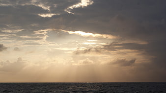 Dramatic Sun Rays Breaking Through Clouds Over Ocean