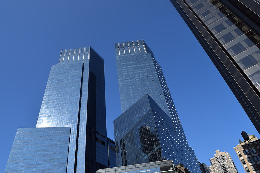 Low angle view of modern glass skyscrapers against blue sky