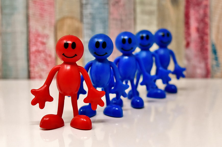 Red leader figurine standing in front of blue team members