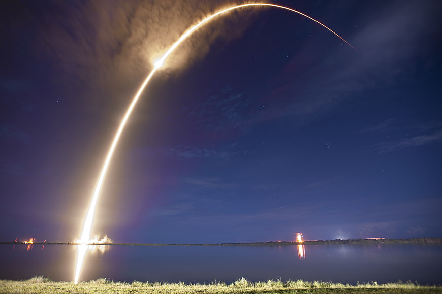 Rocket Launch Trajectory Arc Over Water At Night