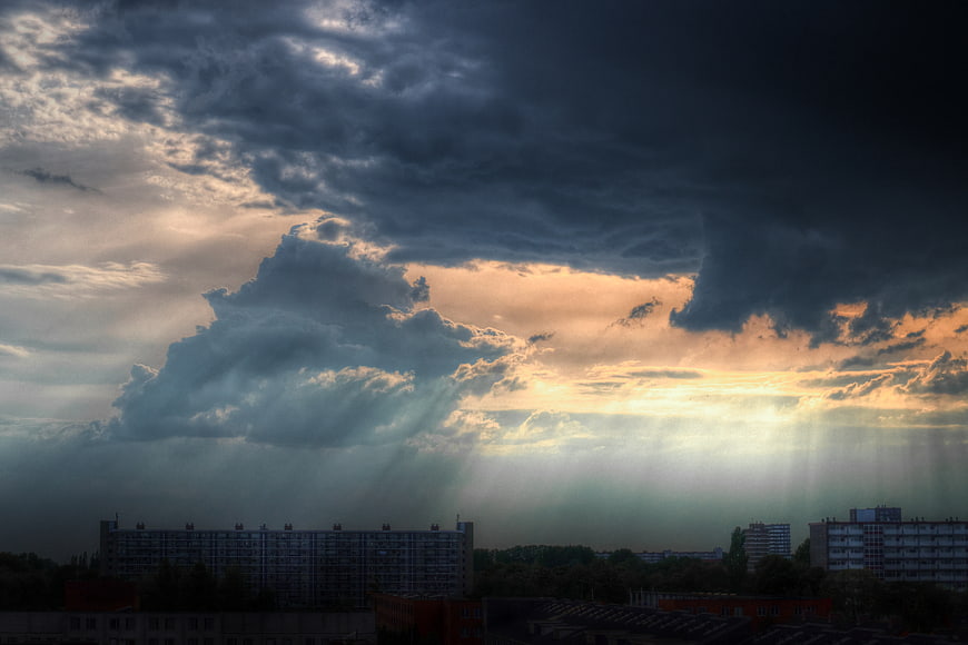 Dramatic sunset with sunbeams over city skyline