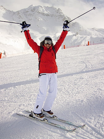 Happy Woman Skiing with Arms Raised on Snowy Mountain Slope