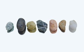 Seven Natural River Stones Arranged in a Row on White Background