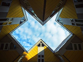 Low angle view of yellow cube houses against blue sky