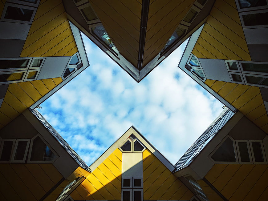 Low angle view of yellow cube houses against blue sky