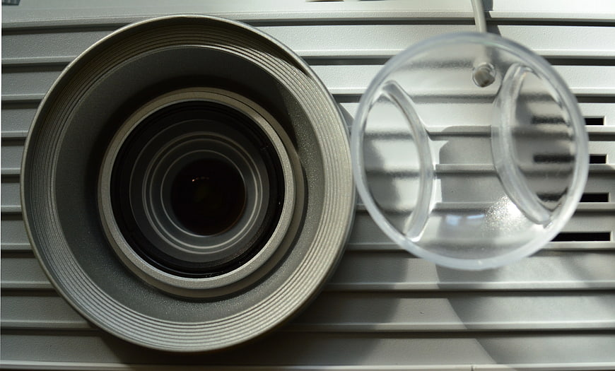 Close-up of vintage camera lens and clear cap on gray slats