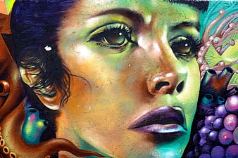 Vibrant street art mural of a woman's face with surreal elements