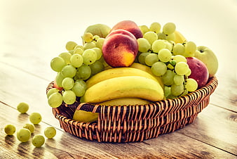 Wicker Basket of Fresh Summer Fruit on Wooden Table