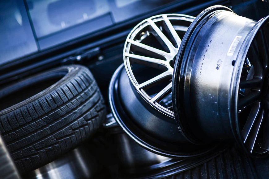 Close-up of car rims and tire in vehicle trunk