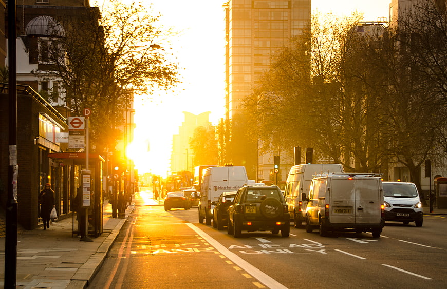 Golden hour traffic on London street with bus stop