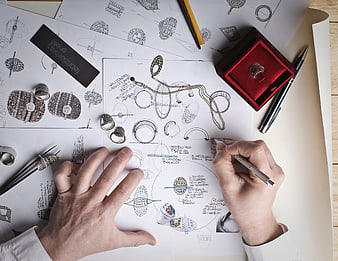 Jewelry designer sketching ring designs on paper