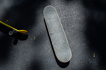Top view of worn skateboard deck on asphalt