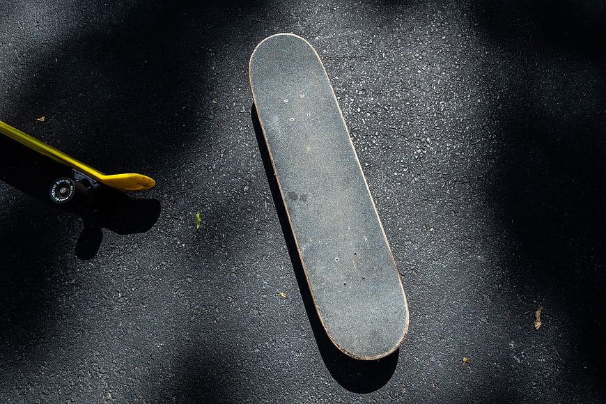 Top view of worn skateboard deck on asphalt