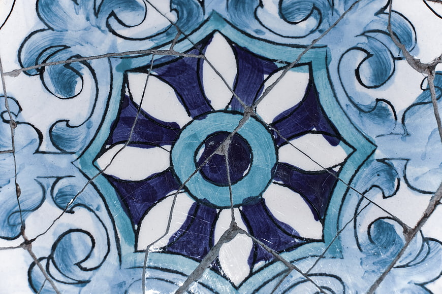 Close-up of cracked blue and white ceramic tile pattern