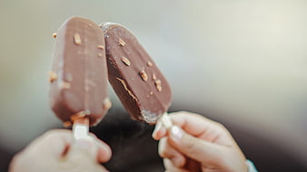Two Hands Holding Chocolate Ice Cream Bars