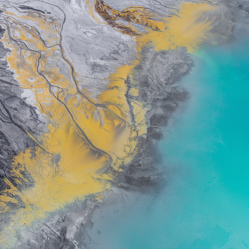 Aerial view of yellow sediment plume in turquoise water
