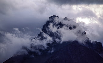 Dramatic Mountain Peak Shrouded in Dark Stormy Clouds