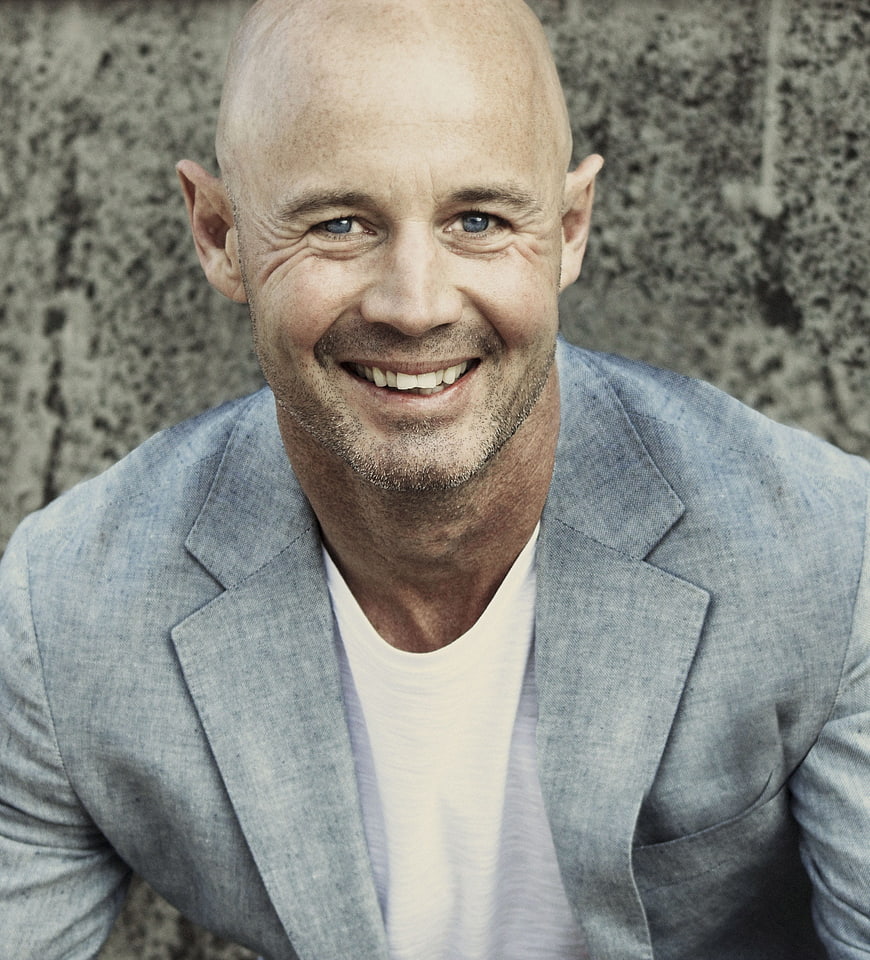 Portrait of Smiling Bald Man in Blue Blazer