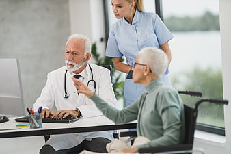 Senior Doctor Consulting with Elderly Patient and Nurse